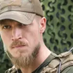 Емблема 16-го армійського корпусу на тлі військової техніки